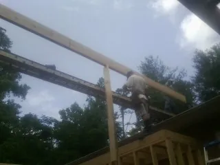 Carpenter setting a ridge beam over a new addition frame — Ice Dam Removal by Roofing Brothers in Clifton